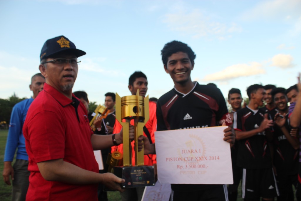 Pembantu Rektor (PR) III Unsyiah, Alfian Yulianur, memberikan piala kepada Syari'ah FC yang menjadi juara Piston Cup ke 29. (Murti Ali Lingga/DETaK)