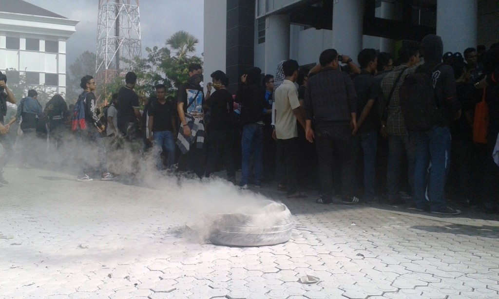 Usai membakar ban bekas, mahasiswa kembali merapatkan barisan ke dalam Gedung Rektorat.