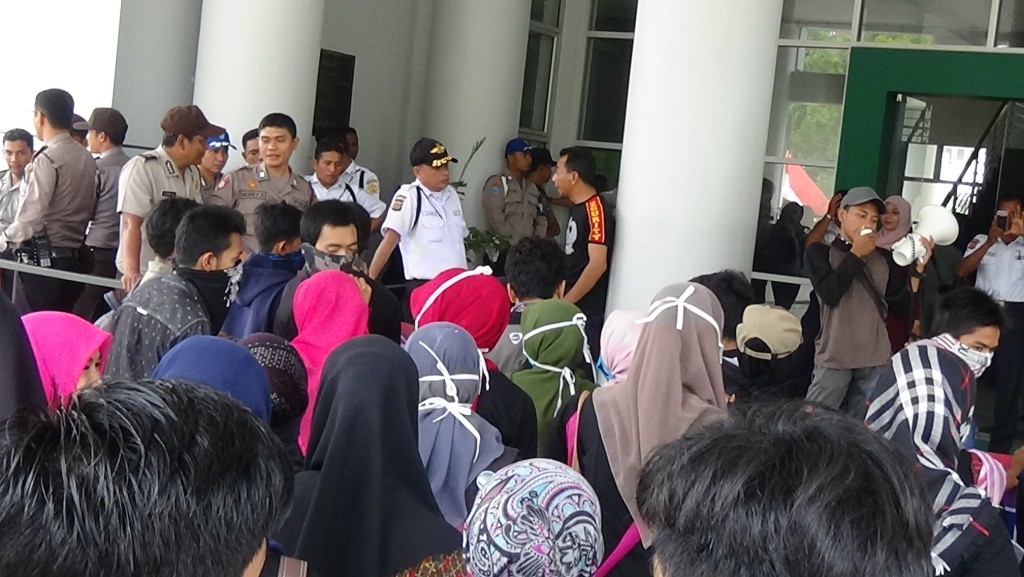 Pihak keamanan kampus dan polisi mengawal aksi demo mahasiswa di depan Gedung Rektorat. (Riska Iwantoni/DETaK)